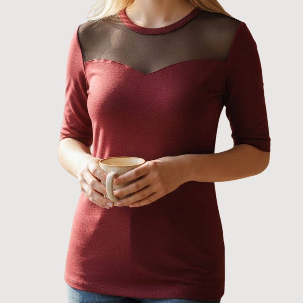Modelo luciendo blusa casual moderna color vino para mujer con manga 3/4,cuello redondo y un panel superior color negro.